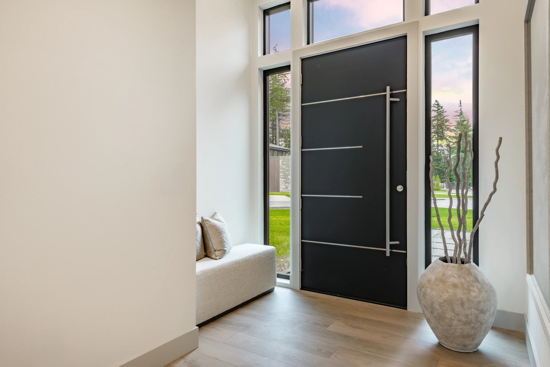 Extérieur résidentiel avec portail coulissant automatique gris anthracite et portillon assorti installés devant une maison moderne blanche